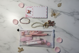 Pink Bow Gift Set flat lay with mesh pouch, pearl bow keychain, butterfly notepad, and beaded bracelet
